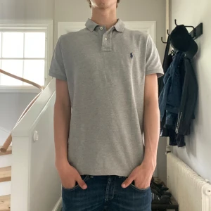 Grå Ralph Lauren pike - Grå Ralph Lauren pike i mycket bra skick🤩| Storlek: M | Jag är 182 och väger 65📏| Vid frågor eller pris diskussion är det bara att skriva ✍🏼 | Frakt inom 48h📦
