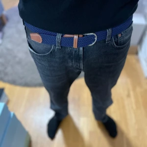 Blått flätat bälte med bruna skinn-detaljer - Säljer ett stilrent blått flätat bälte med snygga bruna skinn-detaljer och silverfärgat spänne. Perfekt accessoar för att lyfta din outfit. Passar till jeans och chinos. Aldrig använt! Nytt skick!