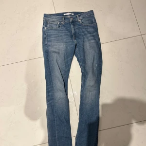 Blå jeans från Calvin Klein - Säljer ett par klassiska blå jeans från Calvin Klein. Modellen har fem fickor, normal passform och raka ben. Perfekta till vardags och lätta att matcha med olika stilar. Storlek W29 L34.