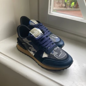 Valentino Garavani sneakers med blått camouflagemönster - Säljer ett par snygga sneakers från Valentino rockrunners. har använts ett fåtal gånger och är då i ett väldigt bra skick. priset kan diskuteras vid en snabb affär 