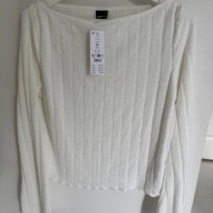 Vit ribbad långärmad tröja från Gina Tricot - Säljer en vit långärmad tröja från Gina Tricot i storlek M. Tröjan har ribbat mönster och rund halsringning. Perfekt för lager-på-lager och enkel att matcha med olika outfits.