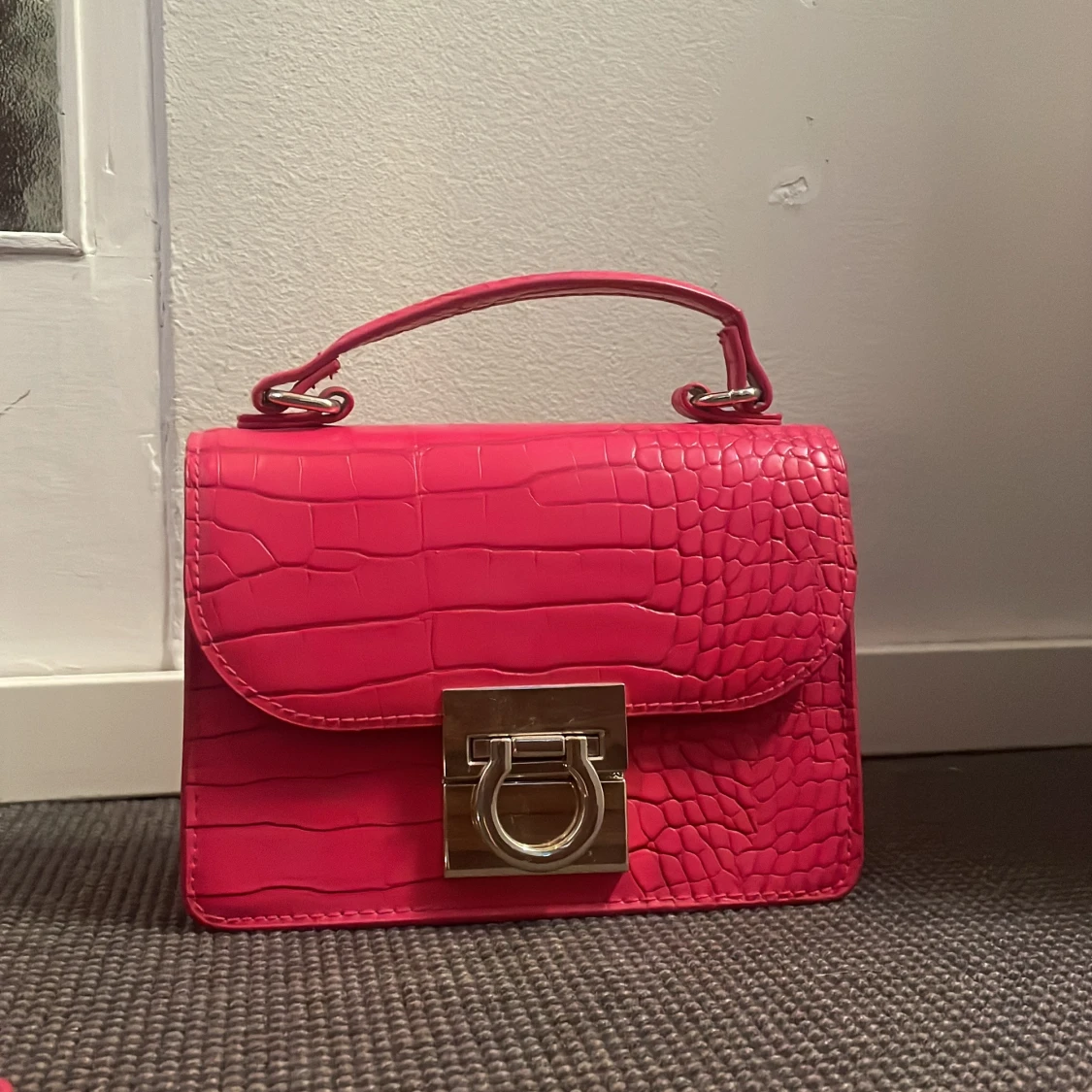 Rosa axelväska med krokodilpräglat mönster