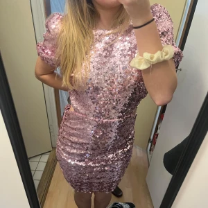 Rosa paljettklänning med puffärm - Säljer denna glitterbomb då den tyvärr inte används längre. Buy the dress and let the occasion find you är en bra beskrivning! Har haft nog med studentfester där denna har kommit till användning. Tyvärr är dessa tider över, och därmed säljer jag klänningen🫶 Jag är mer mot storlek M och den sitter bra! Klänningen är använd men känns som ny. Köpte för flera år sedan för 799 från Nelly men säljer för 200. Kan absolut gå ner i pris vid snabbt köp. klänningen är superskön på insidan