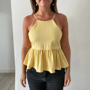 Gul och vit rutig linnetopp med volang - Super gullig gul och vit rutig linnetopp från zara med smala axelband och volang nertill. Toppen har också en söt rosett i ryggen🎀🤍 