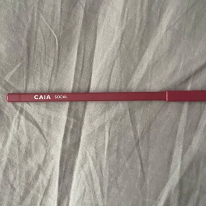 CAIA läppenna Socal - Mörkrosa läppenna från CAIA i nyansen Socal. Pennan har en klassisk trädesign med matchande lock och ger en matt finish. Perfekt för att definiera och forma läpparna med precision.