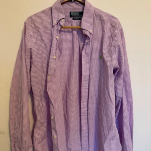 Ljuslila rutig skjorta från Polo Ralph Lauren - Skjortan är använd rätt många gånger men har ej några hål eller liknande