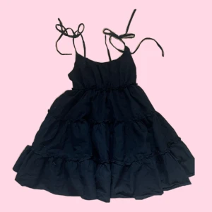 Svart volangklänning med smala axelband - Säljer en svart klänning med smala knytbara axelband o flera volanglager. Klänningen har en luftig och fluffig passform. Materialet känns mjukt och lätt! Den är köpt här på plick men knappt använd 🩷funkar för s och m skulle jag säga