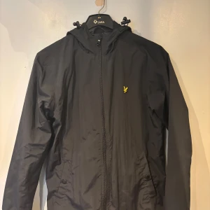Svart och tunn allväderjacka- Lyle & Scott - S - Tunn Lyle & Scott-allväderjacka med luva. Mycket bra skick. Storlek S. 