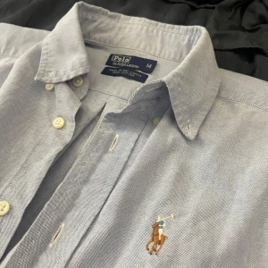 Ralph Lauren skjorta - Säljer nu denna ljusblå Ralph Lauren skjorta som är perfekt till sommaren och lite finare tillfällen. | Skjorta är i fint skick men har några små täcken på användning. Skicket är 8/10 skulle jag säga. | Och det är bara att höra av sig om man har några frågor eller liknande.