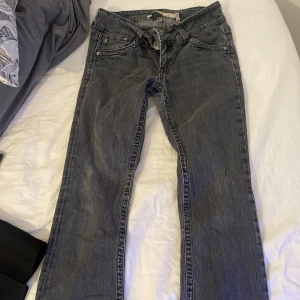 Grå jeansbyxor med raka ben - Säljer ett par low waist  grå jeansbyxor med raka ben och normal passform. Byxorna har fem fickor, knapp- och dragkedjegylf samt detaljerade bakfickor. Perfekta till vardags och enkla att matcha med olika toppar. Priset kan diskuteras 