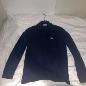 Mörkblå långärmad pikétröja Lacoste - Säljer en klassisk mörkblå långärmad pikétröja från Lacoste i storlek XS (typ som S). Tröjan har inte använts särskilt många gånger och är i bra skick. Nypris: 1500, mitt pris: 350. Skriv privat för fler bilder! 🤩