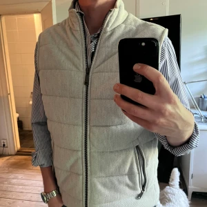 Zara dunväst - Snygg ljusgrå quiltad dunväst från Zara. Stilren och i nyskick