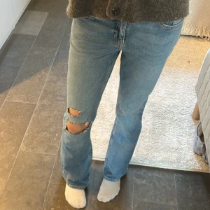 Blå slitna jeans med hål på knät - Säljer ett par ljusblå jeans med hål