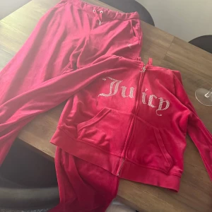 Röd velourset från Juicy Couture - Säljer mitt juicy set då det endast ligger i garderoben pågrund av storleken, använd ett fåtal gånger. Kan gå ner i pris vid snabb affär. Köpt för 2500kr . Tröja i storlek M och byxor i storlek L 