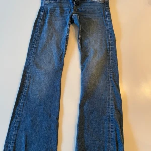Gina Tricot jeans bootcut - Snygga jeans från Gina tricot. Det är bootcut low waist jeans. Storlek 140. De är i färgen blå med snygga knappar där bak.