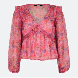 Rosa blommig volangblus  - Superfin blommig blus från Bik bok i rosa. Blusen har volangdetaljer, v-ringning och långa ärmar i ett lätt och luftigt, mycket bra skick!