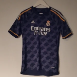 Real Madrid T-shirt  - Säljer en Real Madrid T-shirt borta stället i storlek S. Inget namn eller nummer på ryggen. Kolla profilen för mer fotbollströjor och grisch kläder bland annat.