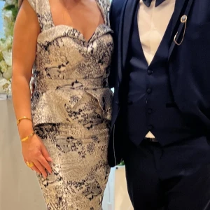 Silverfärgad långklänning med mönster - Elegant balklänning i figurnära snitt, storlek 38–40. Champagnefärgad med vackert vävt mönster i svart och grått. Endast använd en gång – i princip som ny! Figurnära modell med markerad midja, utsvängd nederdel och djup sweetheart-ringning. Perfekt för bal, bröllop eller fest.  📦 Snabb leverans – skickas samma dag! Kontakta mig gärna vid intresse eller funderingar! 📌 