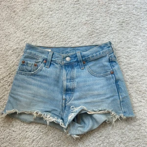Ljusblå jeansshorts från Levi's - Säljer dessa klassiska ljusblå jeansshortsen från Levi's då de är för små för mig. Shortsen har normal passform, knappgylf och medelhög midja. Perfekta för sommaren och enkla att matcha med allt. Skriv vid fler frågor eller funderingar!