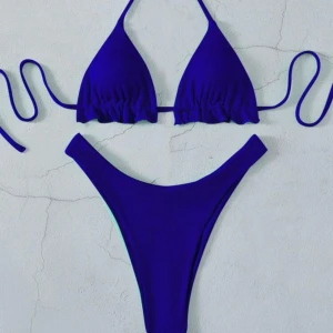 Blå ribbad bikini med knyt - Snygg blå bikini med ribbad struktur. Överdelen har trekantsform och knyt i nacken och ryggen. Underdelen är högt skuren. Den är i storlek S. 