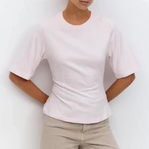 Ljusrosa topp - Enkel och stilren rosa t-shirt från Gina med loose fit och svagt figursydd. T-shirten har rund halsringning och är gjord i mjuk bomull, perfekt för en chill och avslappnad look.