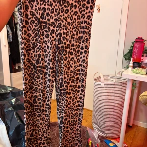 Leopardmönstrade leggings Black V Collection - Snygga leggings i leopardmönster från The Black V Collection. De är stretchiga och sitter tajt, perfekta för dig som vill sticka ut. Färgerna går i beige och svart och materialet känns mjukt och bekvämt mot huden.