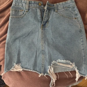 Ljusblå jeanskjol - En jättefin jeanskjol Lin sli li, kjolen är i storlek S men skulle säga att den är lite mindre i storleken, ett exakt skick är jättesvårt att säga då jag köpte kjolen begagnat och aldrig använt den i min ägo då den var för liten, men  när jag kollar igenom kjolen kan jag inte hitta några skavanker, om du har några fler frågor/funderingar eller vill ha fler bilder är de bara att höra av dig till mig, pris går att diskutera 💕
