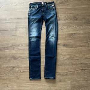 Replay LUZ skinny jeans blå, W25 L32 - Snygga mörkblå skinny jeans från Replay, modell LUZ. Jeansen har klassisk femficksdesign, gul kontrastsöm och Replay-logga på fickan. Materialet är stretchigt jeans och passformen är tight med låg midja. Perfekta för en trendig och avslappnad look. Hyperflex