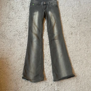 Grå bootcut jeans med slitningar - Snygga grå jeans med bootcut passform. Jeansen är i storlek 27/32 och endast använda ett fåtal gånger💕