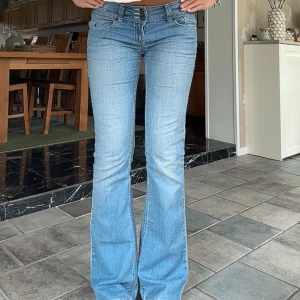 Lågmidjade utsvängda jeans  - Sååå fina jeans!! Vintage, tre knappar och ljusblåa.  Innerben: 82 cm, midja rakt över: 39 cm Kom privat för fler mått eller frågor🥰