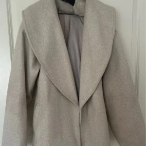 Beige kappa med bälte och bred krage - Pris kan diskuteras. Den är i väldigt bra skick dock är den nopprig på vissa ställen. Framgår i bilderna annars hör av er så skickar jag fler!💕Passar mindre storlekar, har själv S-M så det beror på hur man vill att den ska sitta. 