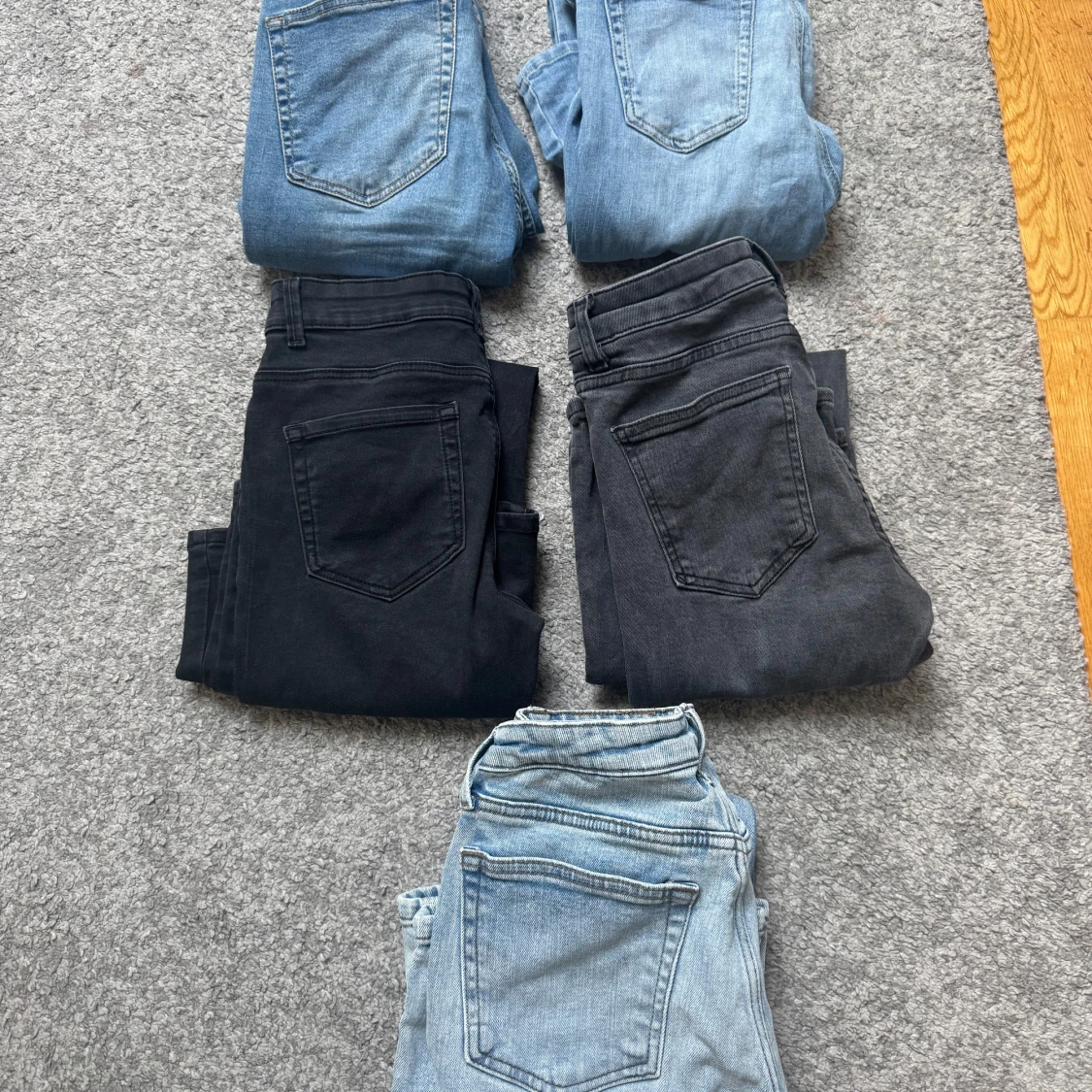 Fem par jeans i olika blå och svarta nyanser