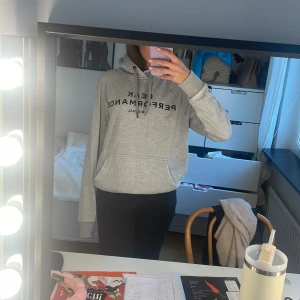 Grå Peak Performance hoodie - Säljer en grå hoodie från Peak Performance med svart tryck framtill. Väldigt snygg och basic, passar både tjejer o killar!🙌
