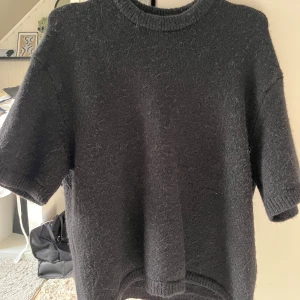Svart stickad tröja från Gina Tricot - Svart stickad tröja från Gina Tricot med kort ärm och rund halsringning. I gott skick🌸💕