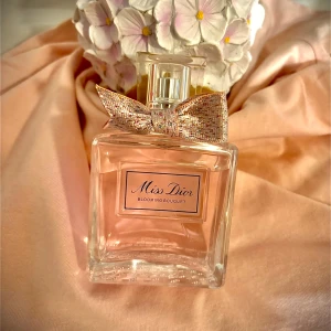 Miss Dior Blooming Bouquet parfym - Miss Dior Blooming Bouquet från Dior är en elegant parfym i en fyrkantig glasflaska med ljusrosa doft och en glittrig rosett vid halsen. Förpackningen är ljusrosa och vit med stilren design. Perfekt för dig som gillar blommiga och fräscha dofter.