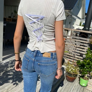 Vit ribbad T-shirt med knytning🍒🤍 - En egendesignad vit ribbad T-shirt med sidenband baktill. Sidenbandet baktill skapar en korsettliknande lock vilket ger mer en mer personlig stil. Perfekt till vardags eller festligare tillställningar. Storlek xs. Obs, ett litet hål på ryggen, se bild🤍🍒