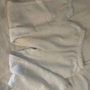 Vita mjukisbyxor med resårmidja - Säljer ett par vita mjukisbyxor med resår i midjan och bensluten. De är gjorda i mjukt material och har en avslappnad passform, perfekta för chill dagar hemma eller när du vill vara bekväm. 