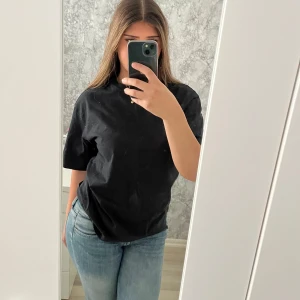 Svart relaxed fit t-shirt från H&M - En svart t-shirt från H&M med rund hals och korta ärmar. Modellen är enkel och stilren utan mönster eller detaljer, tillverkad i mjuk bomull som är skön mot huden. Knappt använd. Hör av dig vid frågor!