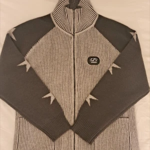 Grå stickad zip-up kofta med stjärnor  - grå stickad zip-up kofta med stjärnor på ärmarna från Cynismo! säljer för att den tyvärr inte passar mig.