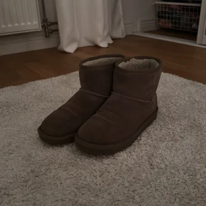 Beiga uggs - Mysiga bruna boots i mocka från Colors of California med mjukt foder och platt sula. Perfekta för kalla dagar, med klassisk rund tå och enkel design. Snygga till jeans eller leggings för en chill vinterlook. vattentäta och i väldigt bra skick.