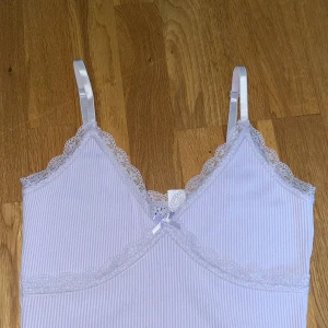 Ljuslila spetsklänning  - Supersöt ljuslila kortklänning från H&M Divided med smala axelband, ribbat tyg och spetsdetaljer vid urringning och under bysten. Liten rosett framtill för extra gullig touch. Oanvänd då den inte passar😊