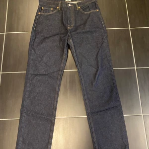 Mörkblå jeans från Lager 157 Seattle - Snygga mörkblå jeans från Lager 157, modell Seattle med klassisk femficksdesign och raka ben. Jeansen har kontrastsömmar och är tillverkade i ett robust denimtyg som ger en tidlös look. Perfekta för dig som gillar enkel och stilren stil.