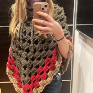 Stickad poncho  - Stickad poncho som används fåtal gånger, i rött, beige o mörkgrönt 