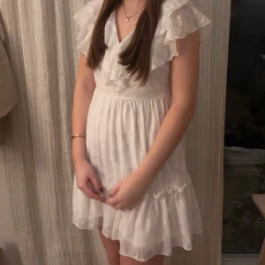 Studentklänning  - Jättefin vit studentklänning med volangdetaljer och v-ringad design. Säljer då jag inte tyckte den passade helt och hållet. Som i nyskick. Stl S, som referens är jag ca 170 cm lång 💖