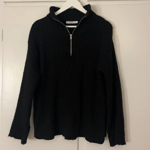 Svart ribbad tröja från NA-KD - Säljer en svart ribbad tröja från NA-KD med dragkedja framtill. Tröjan har en hög krage och långa ärmar, perfekt för kyligare dagar. Enkel och stilren design som passar till det mesta. Lite nopprig, främst längst armarna och kanterna av tröjan men inget som syns mycket! 