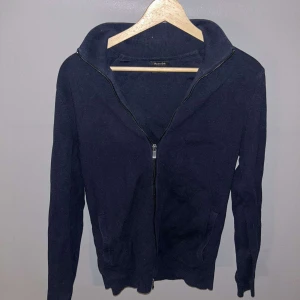 Mörkblå tröja med full zip från Massimo Dutti - Säljer en stilren mörkblå tröja från Massimo Dutti. Tröjan har en praktisk dragkedja framtill och långa ärmar. Perfekt för en avslappnad och snygg outfit.