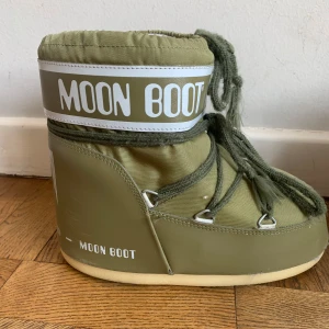 Gröna Moon Boots - Säljer ett par gröna Moon Boots med snörning och vit logga i storlek 39-41  Perfekta för vintern med sin varma och bekväma design. Sulan är svart med bra grepp för hala underlag. Obs små i storlek, passar 39.(färg, khaki)