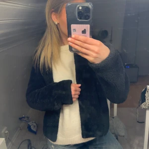 Svart teddyjacka - Mysig svart teddyjacka med långärmad design. Perfekt för kyligare dagar och ger en avslappnad look. Jackan har en enkel och stilren stil som passar till många olika outfits. Jackan är inte tjock den är mer som en kofta typ🥰