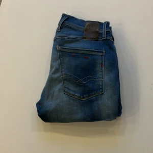 Replay anbass - Snygga blå jeansbyxor från Replay i modellen Anbass. De har en klassisk femficksdesign och en knappgylf. Jeansen har en lätt tvättad look som ger en avslappnad stil. Nypris 2000 vårat pris 299