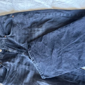 Svarta jeans från Stradivarius - Snygga svarta jeans från Stradivarius i storlek 42. De har en klassisk design med fem fickor och knappgylf. Perfekta för en stilren look.